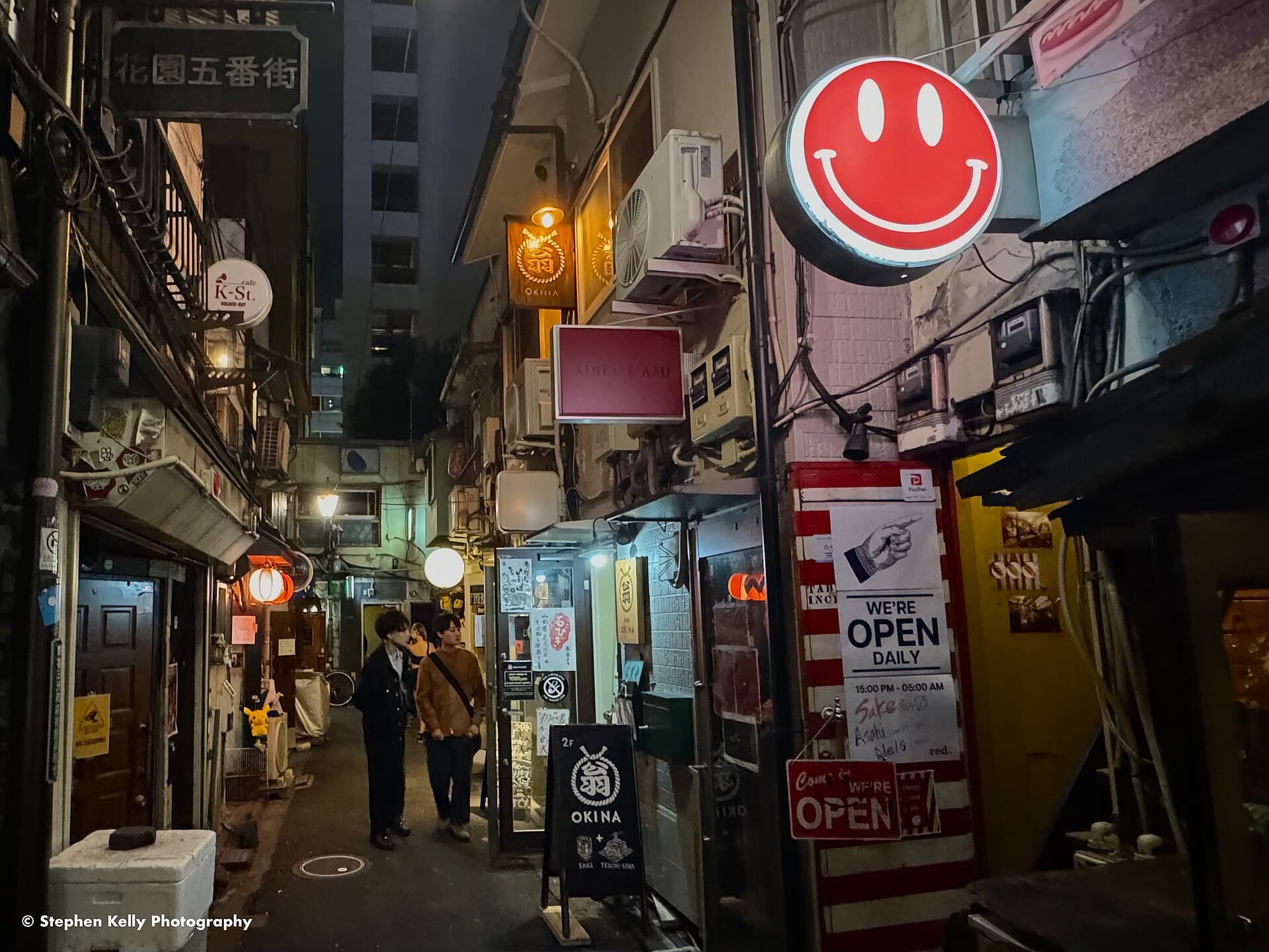 Colorful signs and visitors in Shinjuku Golden Gai at night